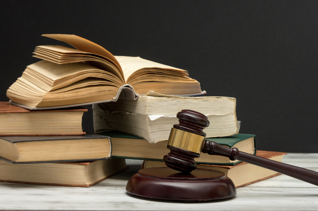 Marteau de la justice devant une pile de livres de droit.