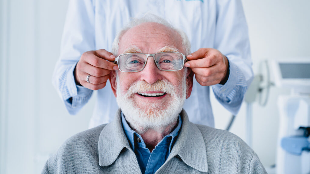 Un âgé avec la barbe et les cheveux blancs essaie des lunettes.